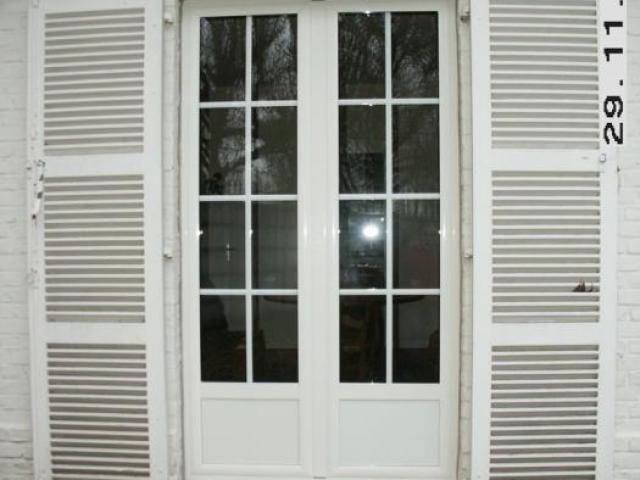 Porte fenêtre en aluminium avec sous bassement plein et croisillion dans les doubles vitrages
